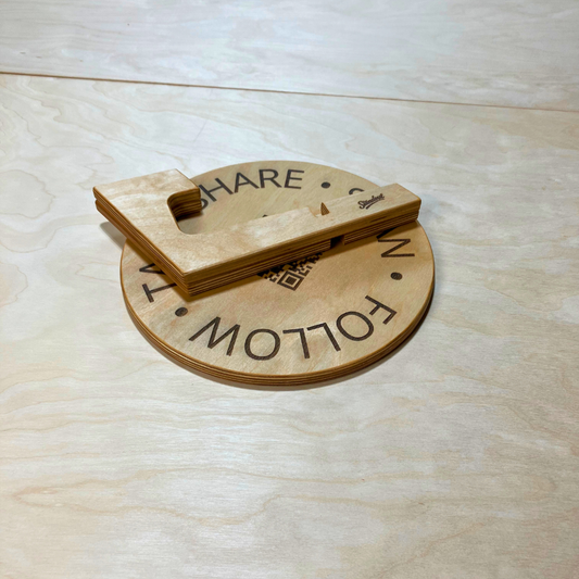 Wooden sign with 'SHARE' and 'FOLLOW' text on a light wood surface