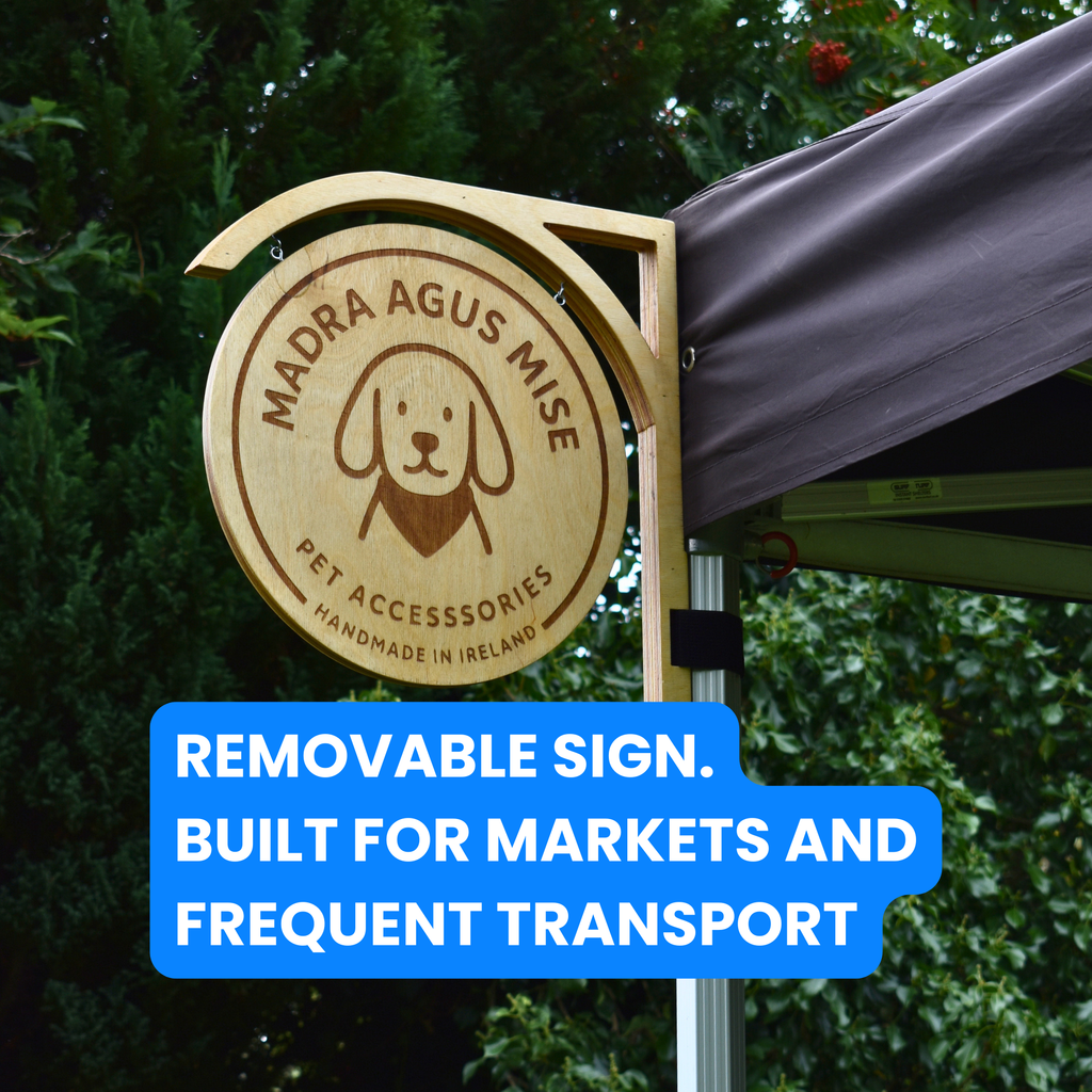 Wooden sign with 'Madra Agus Mise' branding on a green background