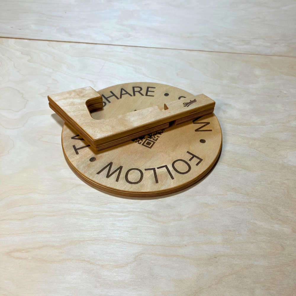 Wooden sign with 'SHARE' and 'FOLLOW' text on a light wood surface
