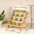 Wooden display stand with gold containers labeled 'Bean-to-Bar Chocolate' on a wooden background.